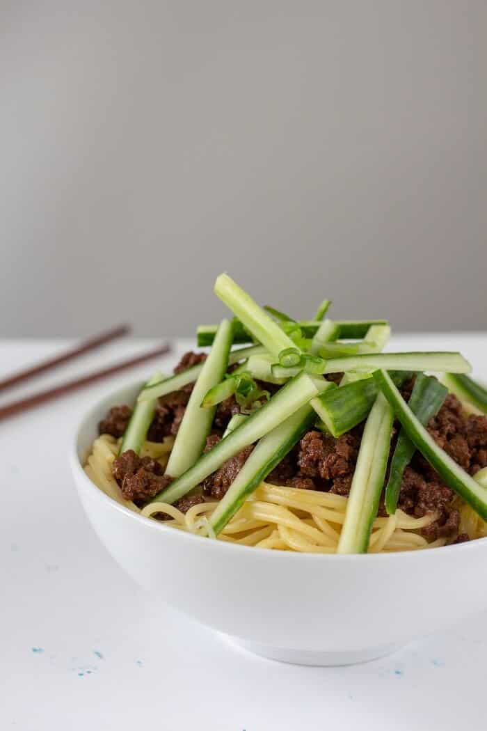 Top a big bowl of rich zha jiang mian (think a pork or beef ragu flavored with some sweet bean sauce) with plenty of cucumber and green onions to keep it fresh. #chinese #asian #noodles