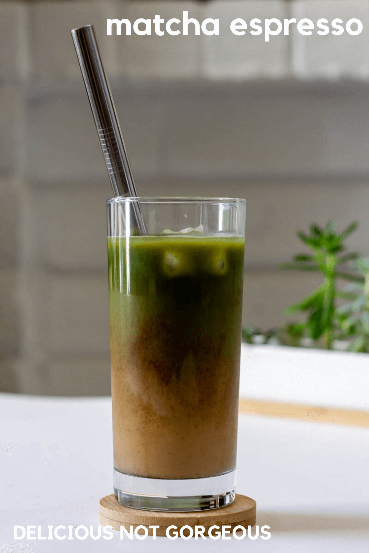Glass filled with ice chunks, a shot of espresso, creamy milk and matcha.