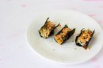 Three little packages of spoonfuls of rice topped with imitation crab salad, tucked into crispy seaweed.